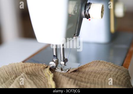 Macro view of sewing machine foot and needle with tangled threads. Stock Photo
