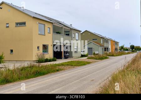 Malmö area, Sweden ; August 4, 2025: Newly occupied semi-detached houses with wooden balconies and parking along a provisional road surface in a new r Stock Photo