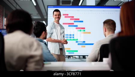 Multicultural Team Presenting Gantt Chart During Office Training Session Stock Photo