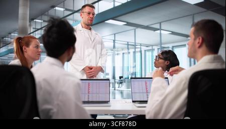 Multiracial Medical Team Collaborates Using Laptops In Hospital Setting. Stock Photo