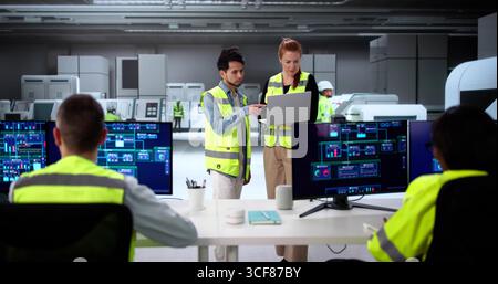 Engineers Using Modern SCADA Software To Control Industrial Plant Stock Photo