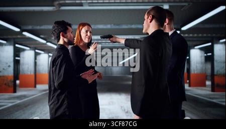 Dangerous Criminal Wielding Gun Menacingly At Young Female Banker Stock Photo