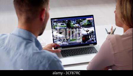 Home Security Technician: Monitoring Live Feed On Laptop From Surveillance Camera. Stock Photo