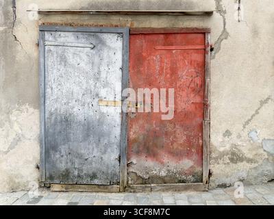 Old damaged wooden entrance door of brick building Stock Photo