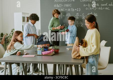 Group of Diverse Teenagers Preparing for Class with Teacher Explaining Math Stock Photo