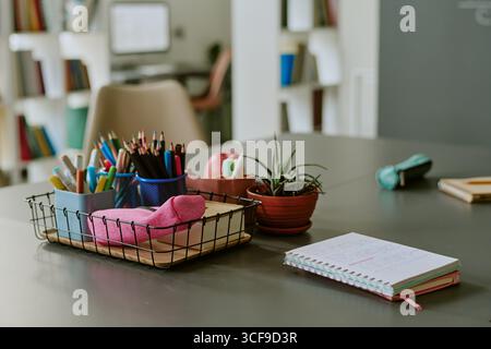 Organizing School Supplies and Taking Notes on Desk in Classroom Setting Stock Photo