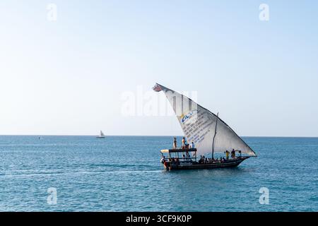 Traditional dhow sailing with tourists off Kendwa Beach, Zanzibar Stock Photo