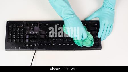 Cleaning Computer Keyboard In Office With A Wet Wipe Rag, Dusty And Dirty Electronic, Housework Stock Photo