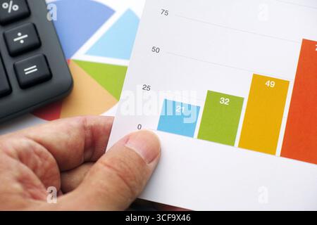 A man holding a financial graph or stock market data in his hand. Close up. Stock Photo