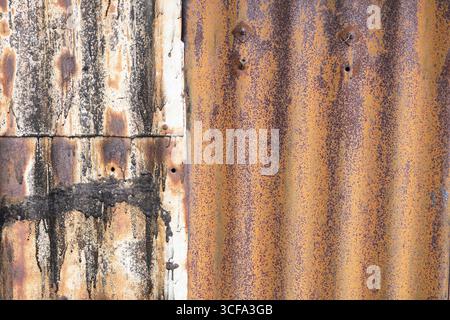 Close-up image of rusty metal sheets displaying contrasting patches and patterns, featuring textures and colors that evoke age, decay, and characteris Stock Photo