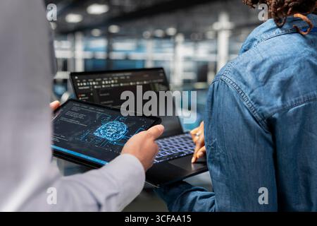 Close up of administrators performing maintenance on supercomputers with AI tools systems. Server farm workers upgrading datasets used for deep learning, neural network analytics. Stock Photo
