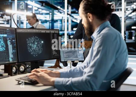 Technician using computer in data center, managing server virtualization, running scripts. IT expert using programming language on PC in server hub, finetuning network protocols Stock Photo