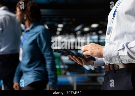 Server farm data scientist using tablet to review AI LLM visualization, intelligent systems for operational stability. Engineer analyzes neural network outputs for stable operations. Stock Photo