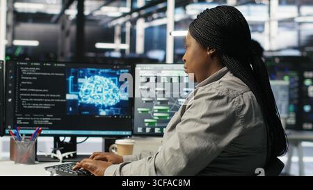 Data center employee deploying AI solutions optimizing equipment. Server farm software developer applying artificial intelligence technology minimizing infrastructure downtime, camera B Stock Photo