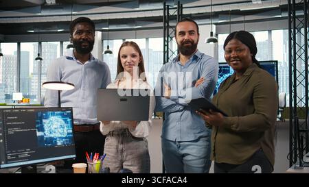 Portrait of happy teamworking engineers writing code, developing machine learning APIs. Team of smiling IT experts troubleshooting software errors using artificial intelligence, camera A Stock Photo