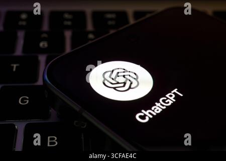 ChatGPT app icon illuminated on smartphone resting on laptop keyboard. Stafford, United Kingdom, August 21, 2025 Stock Photo