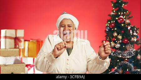 Dance, Christmas and portrait of old woman in studio for holiday season, celebration or xmas cheer. Festive tradition, excited and December vacation Stock Photo