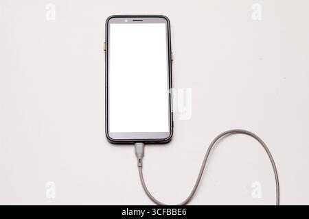 Smartphone Connected to USB Cable with White Background. Stock Photo