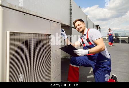 Portrait Of An Engineer Inspecting Hvac System Or Air Conditioner On A Roof Stock Photo