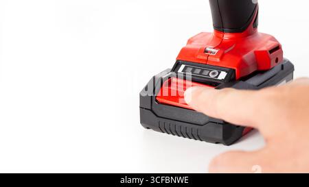 Replacing the battery in a new drill screwdriver on a white background, battery charge and capacity. Stock Photo