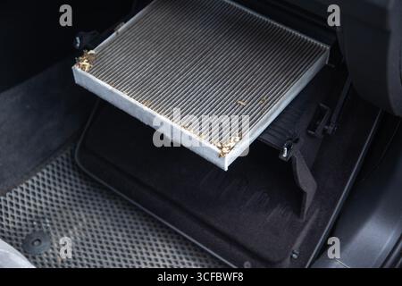 Old dirty carbon cabin filter of the car. Concept of replacement with a new one. Cleaning the air in the car cabin Stock Photo