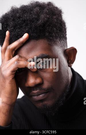 Multiracial handsome brunette man posing in black turtle neck sweater against white background. Successful young man concept. Vertical shot Stock Photo