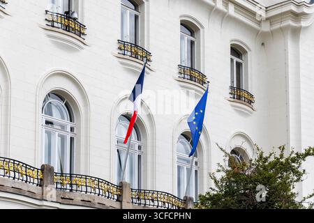 View of French and European Union flags waving beside palm trees and ...