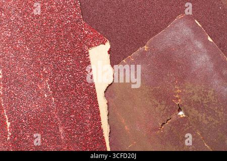 Pieces of used sheet of red sandpapers isolated on a white background Stock Photo