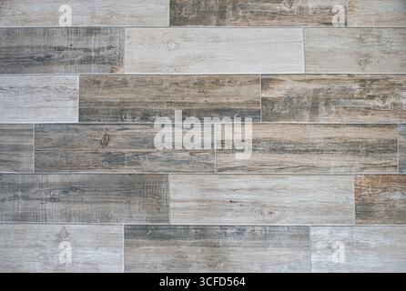 Flooring covered with imitation wood tiles in brown tones with an elongated horizontal format. Top view. Stock Photo