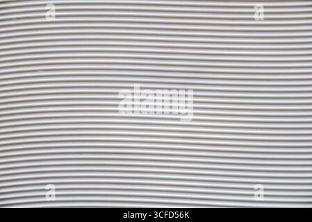 Background with a white plastic base with grooves forming horizontal waves. Top view. Stock Photo