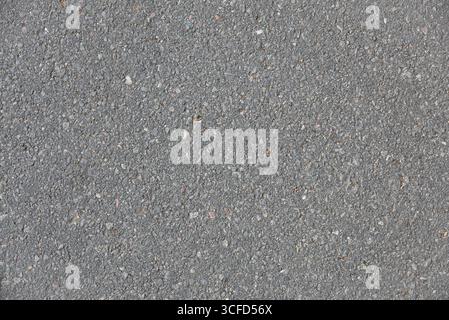 Macro background of dirty worn asphalt detail in medium gray color. Top view. Stock Photo