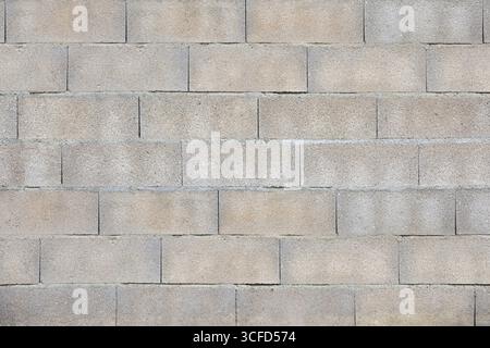 Detail of a wall of gray concrete blocks joined with cement. Front view. Stock Photo