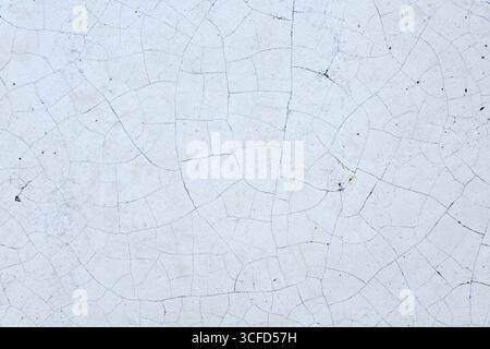 Details of crackled white material with multiple irregular shapes and dark cracks. Top view. Stock Photo