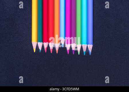 Row of Colored Pencils Aligned on Black Background Stock Photo