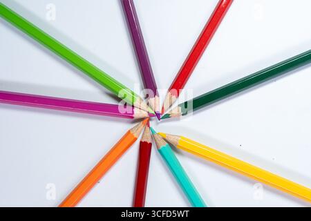 Colored Pencils Arranged in Circle on White Background Stock Photo