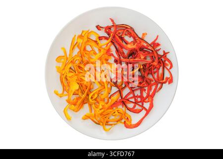 Dried sweet peppers on a ceramic plate isolated on a white background. Various dry of sweet peppers. Ingredient for preparing a freeze-dried lunch. De Stock Photo