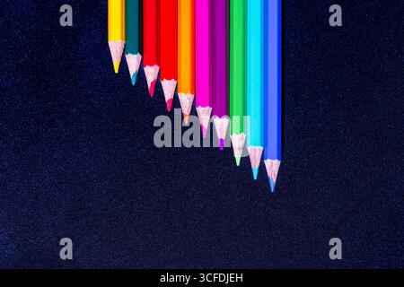 Diagonal Arrangement of Colored Pencils on Dark Textured Background Stock Photo