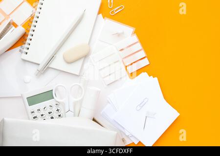 White stationery on orange background, flat lay. Space for text Stock Photo