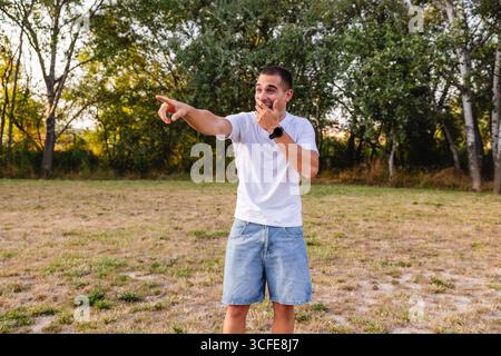 Young man laughing and pointing finger in park Stock Photo