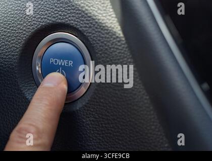 Finger pressing car engine start/stop power button Stock Photo