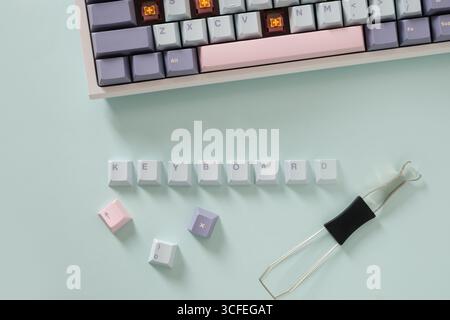 Concept cleaning and customization keycaps in modern mechanical keyboard on blue background. Custom build keyboard keycap. View from above, Stock Photo