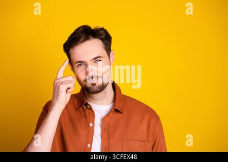 Young man performing thoughtful gesture on vibrant background conveying determination and individuality Stock Photo