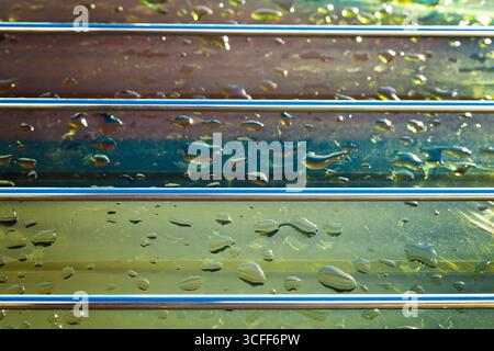 Glass with a steel grating on the surface of which there are drops of water. Stock Photo