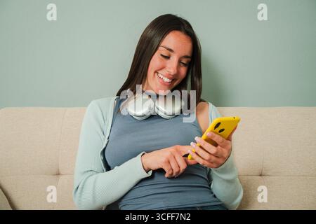 Delighted female using her cellphone and interacting with various applications, showcasing a moment of relaxation and joy, while enjoying her time on Stock Photo