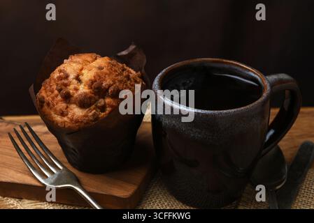 A mug of coffe with fresh baked muffin on a cafe table. Stock Photo