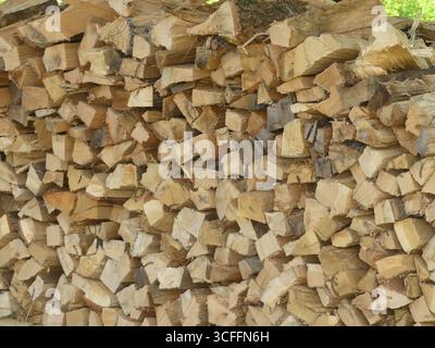 A dense, full-frame macro texture of neatly stacked split firewood logs showing varied end grain and split fibers Stock Photo