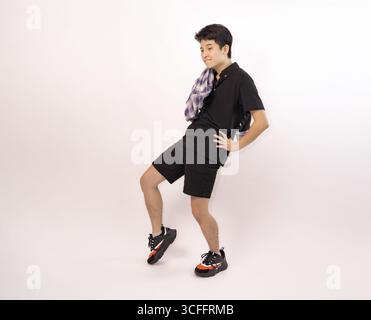 young man posing playfully in checkered shirt with casual outfit Stock Photo
