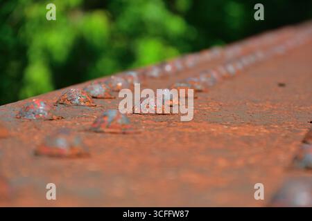 Rusted rivet on steel structure. Rust damage on steel bridge. Heavy duty fasteners on industrial structure. Stock Photo