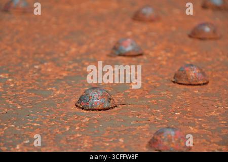 Rusted rivet on steel structure. Rust damage on steel bridge. Heavy duty fasteners on industrial structure. Stock Photo