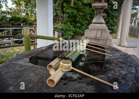 Japanese Purification Basin with Bamboo Ladles. Chōzuya purification basin with bamboo water spout and ladles at a Shinto shrine in Japan. Stock Photo